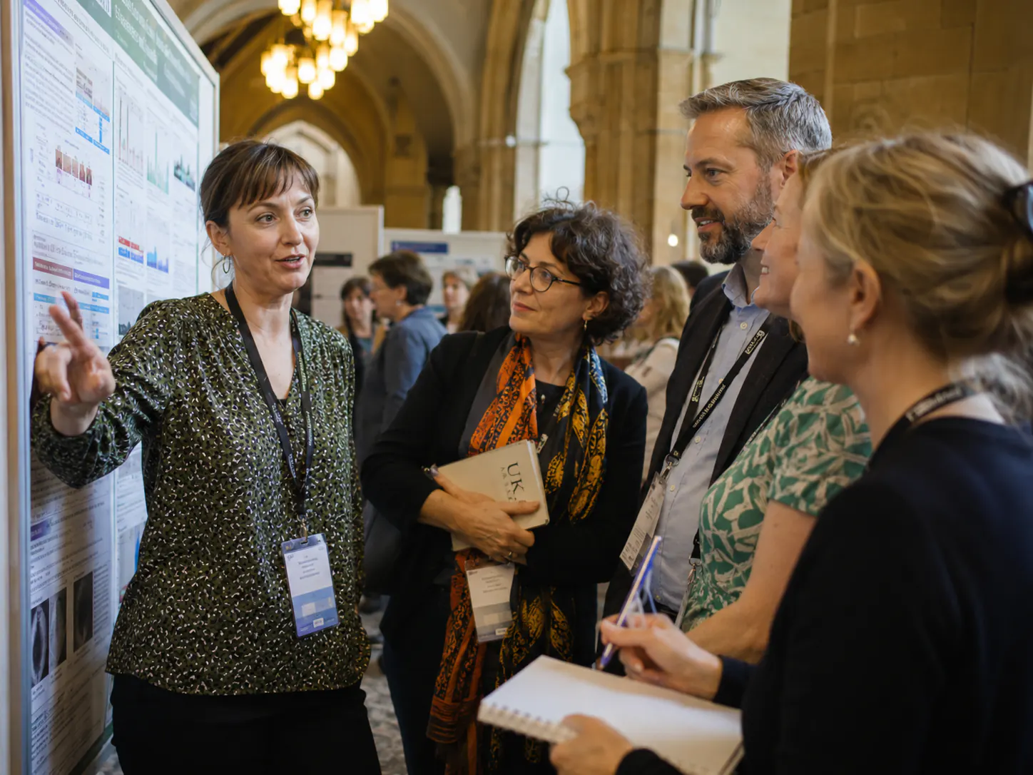 Researchers discussing evidence during a poster session